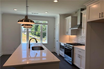 Beautifully appointed kitchen:  quartz counter tops, designer backsplash, pendant lights...GE appliances. 3br New Home in Cumming, GA