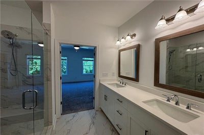 Separate primary vanities with ample cabinet storage. New Home in Cumming, GA
